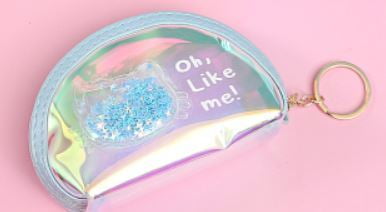 A small iridescent zip pouch in pastel pink, blue, and yellow, with a round keyring, displayed against a soft pink background.